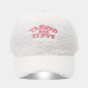 Detail shot showing the fuzzy fleece texture and pink embroidered letters on the baseball cap