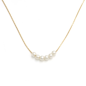 Minimalist 18k gold plated stainless steel necklace with six white pearls on white background