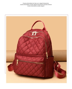 Detail of burgundy oxford backpack showing elegant quilted diamond pattern and golden zippers