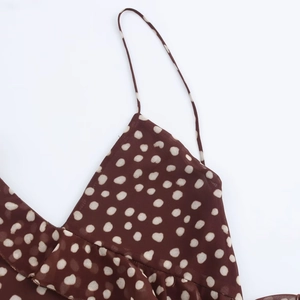 Macro view of brown polka dot chiffon dress featuring ruffle trim and thin straps