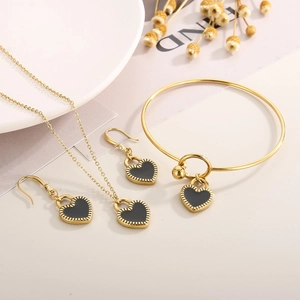 Detail view of heart-shaped jewelry set with black enamel inlay and gold-tone finish