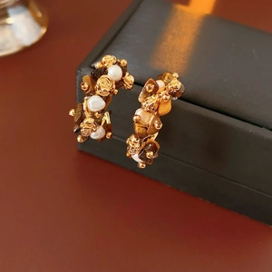 Detail of vintage flower C-hoop earrings with tiger eye stone and white pearls