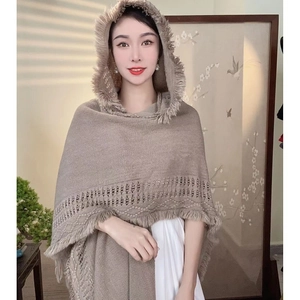 Ethnic style khaki hooded knit shawl with tassels and hollow patterns on a female model