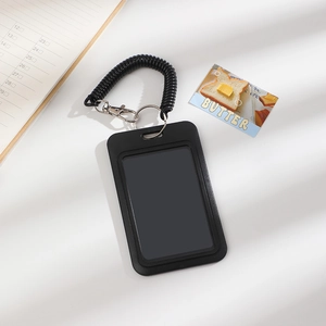 Detail of black plastic ID holder with transparent window and spring coil lanyard