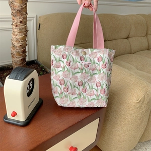 Dettaglio della piccola borsa in tela a fiori con chiusura a bottone automatico in metallo