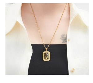 Detail of a vintage gold star and hand tarot pendant necklace worn by a female model