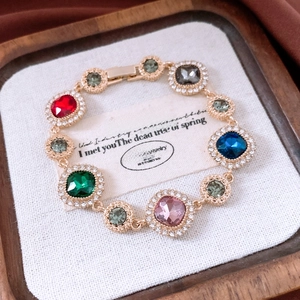 Macro view of vintage gold bracelet with colorful gems and sparkling crystal halo