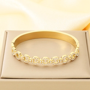 Detailed macro view of gold-tone linked circles bracelet with sparkling white rhinestones