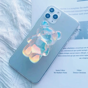 Detailed close-up of a 3D colorful holographic bear phone grip on a smartphone back