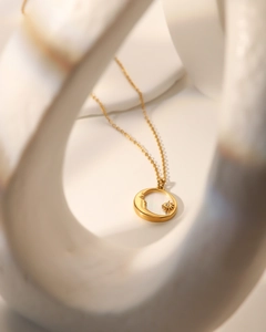 Gros plan artistique du collier doré avec pendentif lune et étoile en nacre blanche