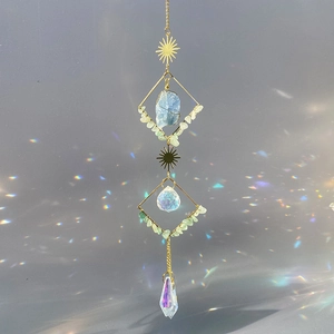 Detail of sun catcher featuring gold metal moon, raw blue stone and rainbow crystals