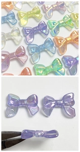 Detail of colorful luminous resin bow beads showing the side hole for DIY jewelry making