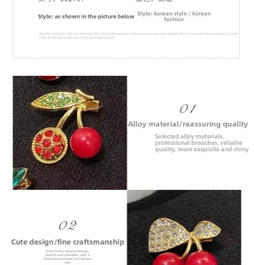 Detailed close-up of cherry brooch with red crystals and gold alloy base