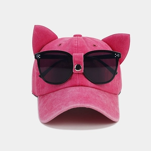 Dettaglio del cappellino rosa con orecchie da gatto e occhiali da aviatore integrati