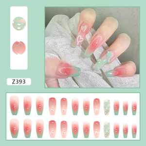 Détail de faux ongles coffin dégradés rose et vert avec motifs de cœur 3D et perles décoratives