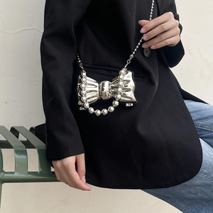 Borsa a mano argento a forma di fiocco con perline e tracolla a catena su modella