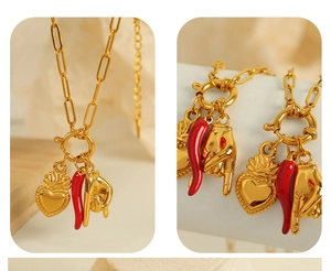 Detail of paperclip chain necklace featuring chili, heart, and rock hand pendants