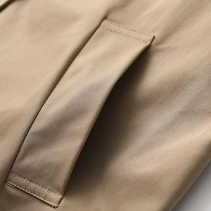 Detailansicht der Khaki-Manteltasche mit präzisen Nähten und hochwertiger Köpergewebestruktur