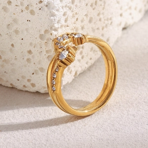 Macro detail of gold-plated crescent ring with sparkling rhinestones on textured stone