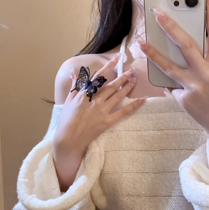 Mirror selfie showing a large black acrylic butterfly statement ring on a finger