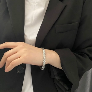 Braided silver titanium steel bangle bracelet for women on model wearing a black blazer