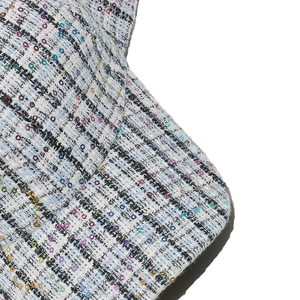 Detailed macro view of tweed plaid fabric with sparkling rainbow sequins on baseball cap