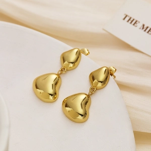Close-up of golden double heart drop earrings with polished organic molten texture