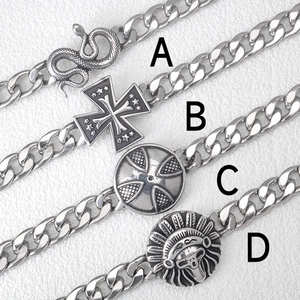 Detail of four punk style stainless steel curb chain bracelets with snake and cross charms
