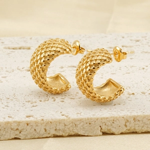 Vue détaillée des boucles d'oreilles en C plaquées or 18K avec texture perlée sur pierre