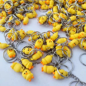 Wholesale pile of cartoon yellow duck keychains with soft PVC bodies and metal rings