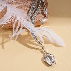 Close-up of silver feather necklace featuring a large oval crystal and sparkling rhinestones