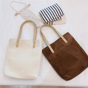 Detailed texture of corduroy tote bags in beige and brown with leather handles