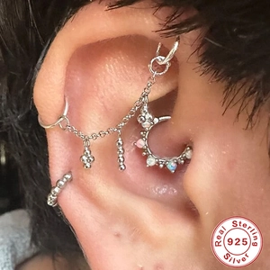 Macro view of 925 sterling silver cartilage chain earring with opal crescent moon charm