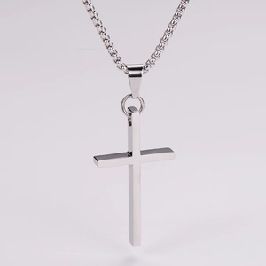 Detailed view of a polished silver cross necklace with a minimalist glossy pendant