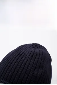 Detail of dark blue knitted winter hat with thick vertical stripe texture and warm fabric