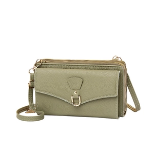Detail view of the green lychee pattern leather texture and dual zipper compartments