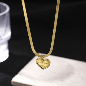 Detail of gold heart pendant with Love You More engraving and snake chain necklace