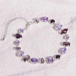 Détail macro du bracelet argenté avec zircons violets de formes géométriques variées