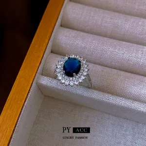 Lussuoso anello in argento con grande zircone blu scuro ovale e doppia corona di diamanti