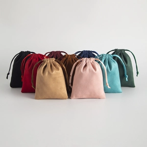Detailed view of drawstring jewelry pouches in various colors with soft suede texture