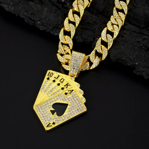 Macro shot of gold-plated cuban chain necklace with diamond iced-out poker cards pendant