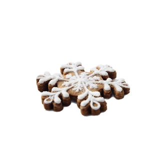Snowflake cookie cutter for Christmas baking featuring white icing on gingerbread