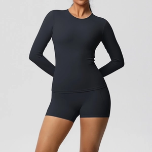 Détail d'un ensemble de yoga noir moulant avec haut à manches longues et short élastique