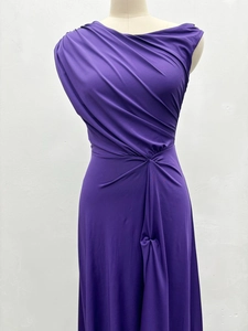 Close-up of asymmetrical pleats and waist draping on deep purple sleeveless maxi dress