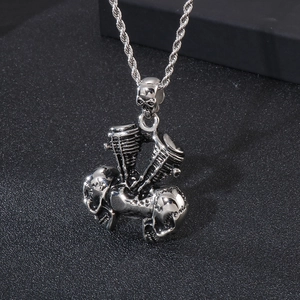 Detailed shot of a silver gothic skull and V-engine motor pendant on a rope chain