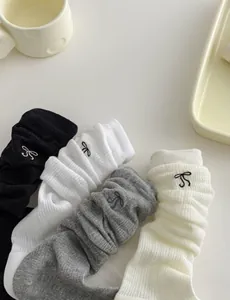 Detailed view of ribbed knit socks with delicate bow embroidery in four pastel colors