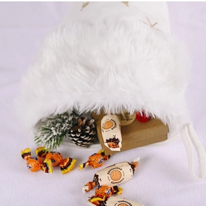 White faux fur Christmas stocking with golden snowflake embroidery and decorative gifts