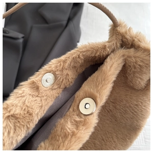 Close-up of secure magnetic snap closure on high-quality brown faux fur tote bag