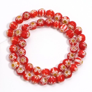 Macro detail of red Millefiori glass beads with white flower patterns and yellow centers