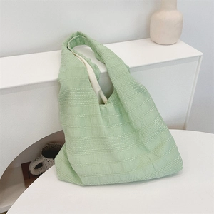 Macro shot of textured avocado green tote bag fabric with subtle white dot details